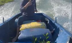 Sular altında kalan bahçesine kayıkla ulaştı