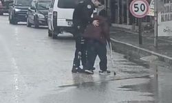 Yunus polisleri, yağmur altında trafiği durdurup engelli vatandaşın yoldan geçmesini sağladı