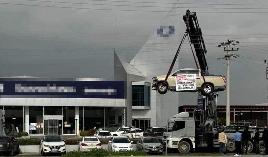 Aldığı sıfır kamyoneti, hatalı çıktığını öne sürüp, bayinin önünde vinçle kaldırarak sergiledi