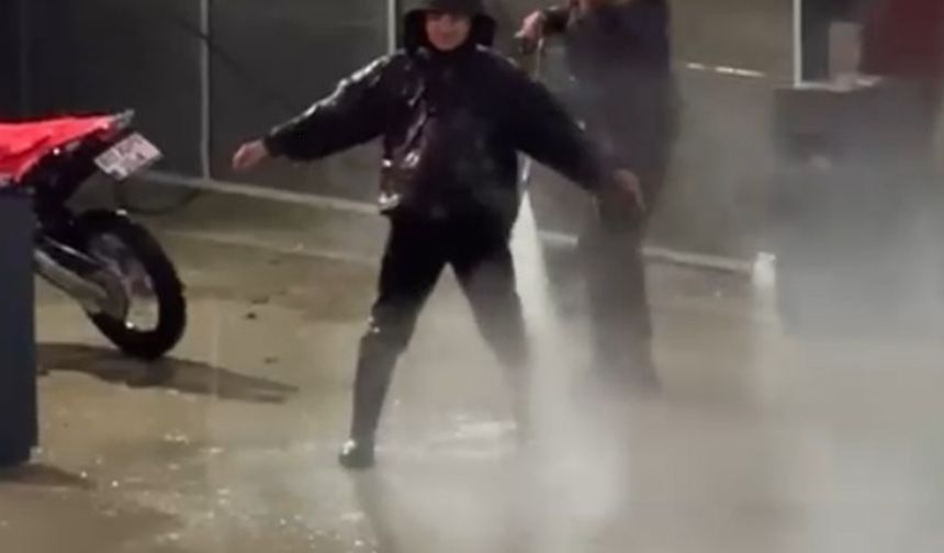 Çamurlu araziden dönen motosiklet sürücüsü, basınçlı suyla temizlendi